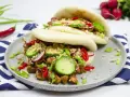 Dwa puszyste bao z kurczakiem, chrupiącym ogórkiem, rzodkiewką i orzeszkami ziemnymi. Idealne na szybki lunch.
