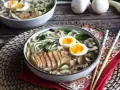 Pyszne ramen z kurczakiem, jajkiem na pół i grzybami. Aromatyczny bulion i delikatny kurczak tworzą idealne danie.
