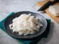 Płaski, biały makaron ryżowy na talerzu, gotowy do przygotowania pysznych dań. Szukasz inspiracji? Sprawdź makaron vermicelli przepisy!
