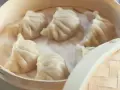 Gorące, parujące pierożki chińskie w bambusowym parowniku. Delikatne ciasto i soczyste nadzienie kuszą smakiem.