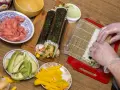Przygotowanie sushi: ryż, awokado, mango, krewetki i marynowany imbir czekają na rolki. Zobacz nasz sushi przepis!