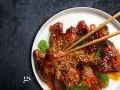 Pyszne skrzydełka teriyaki, błyszczące od sosu, posypane sezamem i ozdobione plasterkami chili.