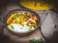 Aksamitne mango curry z ryżem, chrupiącym tofu i świeżą bazylią. Danie prezentuje się apetycznie.