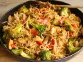 Pyszny makaron smażony z kurczakiem, brokułami i pieczarkami w sosie sojowym, gotowy do podania.