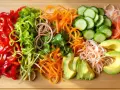 Kolorowe warzywa do sushi: papryka, ogórek, marchewka, awokado, cebula i kiełki. Idealne składniki do przygotowania pysznych rolek.