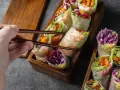 Chwytam pałeczkami świeże sajgonki z krewetkami, czerwoną kapustą i warzywami. Idealne co do sushi!