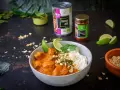 Aksamitny kurczak w sosie massaman curry, podany z ryżem, limonką i posypany orzeszkami. Obok puszka mleka kokosowego i słoiczek pasty massaman.
