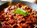 Pyszne wieprzowina po koreańsku w pikantnym sosie, udekorowana zieloną cebulką.