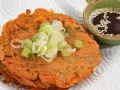 Chrupiące placki z kimchi, posypane szczypiorkiem, obok miseczki z sosem sezamowym. Idealne na przekąskę.