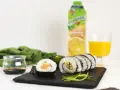 Pyszne sushi z łososiem, ogórkiem i ryżem, podane z sosem sojowym i sokiem pomarańczowym.