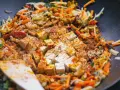 Smażone warzywa po chińsku z tofu i ryżem, doprawione kurkumą i papryką, gotowe do podania.