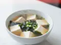 Parująca miseczka zupy miso z kostkami tofu, wodorostami i szczypiorkiem. To właśnie co to jest soja w pysznej, rozgrzewającej formie.