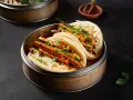 Pierożki baozi z tofu i warzywami, podane w bambusowym parowniku.