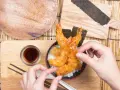 Chrupiące krewetki w cieście tempura na ryżu, gotowe do jedzenia. Idealny przepis na tempurę.
