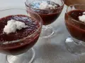Trzy pucharki z deserem z tapioki z mlekiem kokosowym, ozdobione wiórkami kokosowymi.