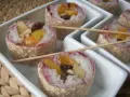 Słodkie sushi owocowe w wafelkach, z ryżem i kawałkami owoców, podane na białych tacach.