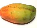 Okrągłe, owalne mango z przejściem kolorów od pomarańczowego do zielonego, z drobnymi, ciemnymi plamkami.
