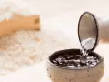 Sake przelewana z dzbanka do czarki, w tle ryż. Poznaj, jak smakuje sake.