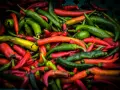Mnóstwo kolorowych papryczek chili, od zielonych po czerwone i żółte. Czy papryczka chili jest zdrowa? Tak, jest pełna witamin!
