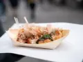 Pyszne takoyaki, czyli japońskie kulki z ośmiornicą, posypane płatkami bonito i zieloną posypką. Idealny japoński street food na wynos.