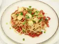Pyszny makaron chow mein z kostkami tofu, papryką i szczypiorkiem.
