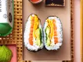 Dwa połówki onigiri z łososiem, awokado i jajkiem, podane na talerzu z pałeczkami.