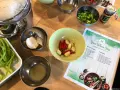 Składniki do zupy **sos tom yum**: czosnek, chili, zielona cebulka, makaron i pasta **sos tom yum** w słoiczku.