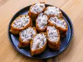 Tofu inari z ryżem i czarnym sezamem na czarnym talerzu.