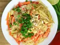 Talerz pełen pad thai z marchewką, tofu i orzeszkami ziemnymi. Zastanawiasz się nad pad thai kcal?