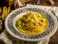 Pyszny makaron curry z kurczakiem i porem w kremowym sosie, ozdobiony szczypiorkiem.