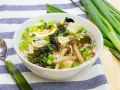 A miska pełna aromatycznej zupy miso z tofu, grzybami, wodorostami, jajkiem i szczypiorkiem.