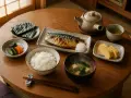 Japońskie śniadanie: ryż, grillowana makrela, zupa miso, tamagoyaki, nori i marynowane warzywa. Smaki Azji na talerzu.