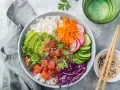 Kolorowy poke bowl: ryż, łosoś, awokado, marchewka, rzodkiewka, ogórek i czerwona kapusta. Idealny posiłek, który zaspokoi głód.