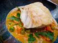 Aromatyczny curry z dorszem, podane z groszkiem i marchewką w kremowym sosie.