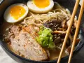 Miseczka aromatycznego ramenu z plastrami mięsa, jajkiem na pół i grzybami. Idealny ramen na szybko, by zaspokoić głód.
