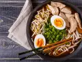 Pyszny shoyu ramen z kurczakiem, jajkiem na twardo, kiełkami fasoli mung i szczypiorkiem.