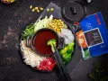 Składniki do hot pot z pastą kimchi: makaron, krewetki, wołowina, brokuły, fasolka edamame, ogórek i zielenina.