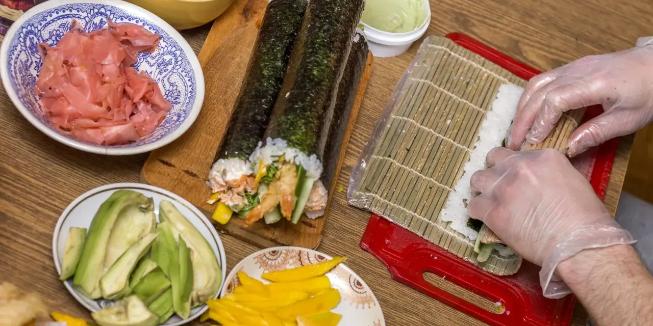 Przygotowanie sushi: ryż, awokado, mango, krewetki i marynowany imbir czekają na rolki. Zobacz nasz sushi przepis!