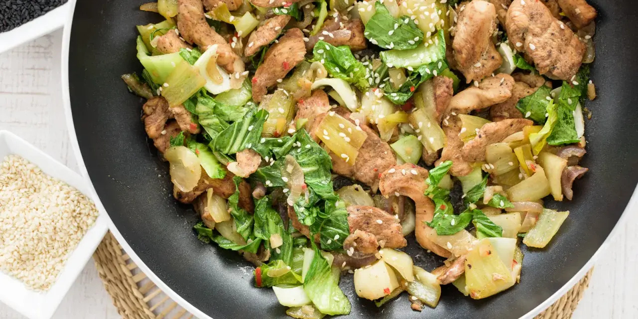 Smażony kurczak z pak choi, posypany sezamem, gotowy do podania.