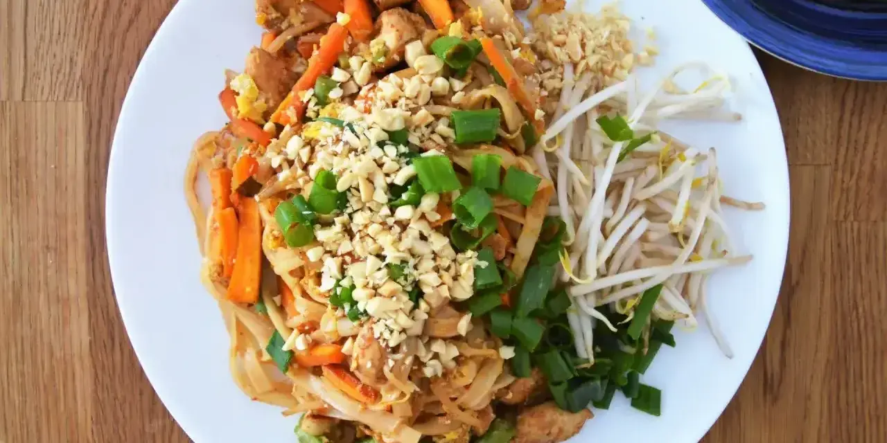 Pyszny Pad Thai z kurczakiem, warzywami i orzeszkami ziemnymi, polany aromatycznym sosem do Pad Thai.