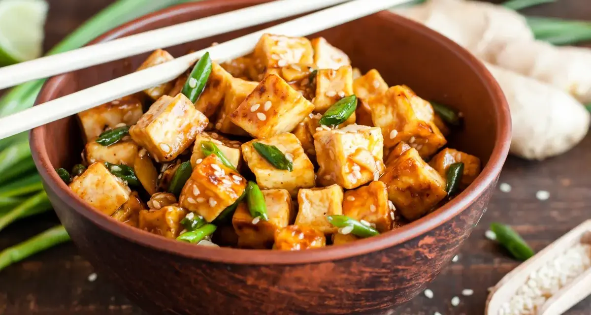 Miseczka pysznego, glazurowanego tofu z sezamem i szczypiorkiem. Zastanawiasz się, ile kcal ma tofu? To zdrowe i sycące danie!
