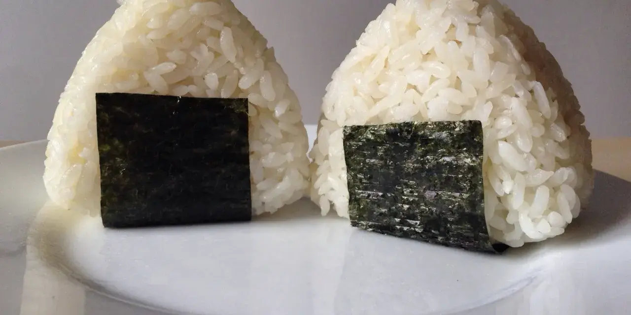 Dwa ryżowe onigiri z nori, gotowe do spożycia. Idealne nadzienie do onigiri sprawia, że są pyszne.