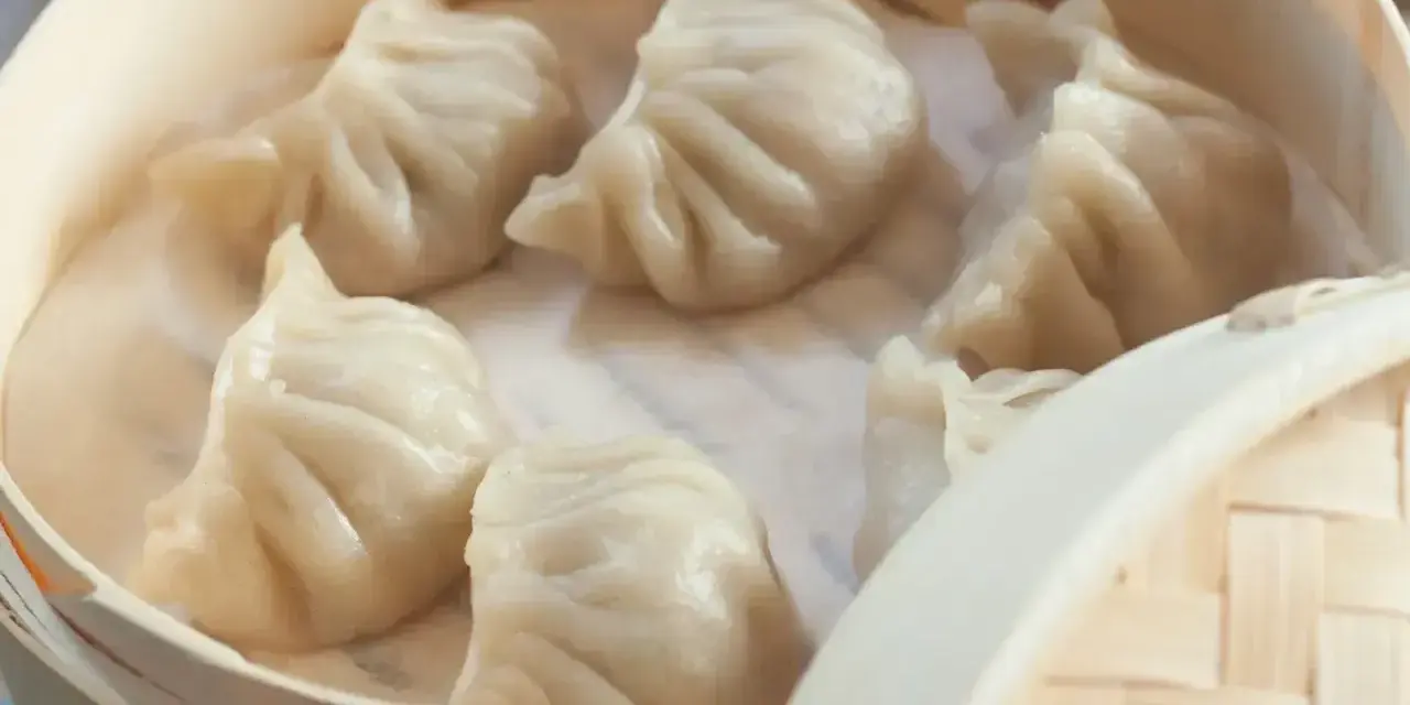 Aksamitne pierożki na parze w bambusowym koszyku, parujące i gotowe do jedzenia.
