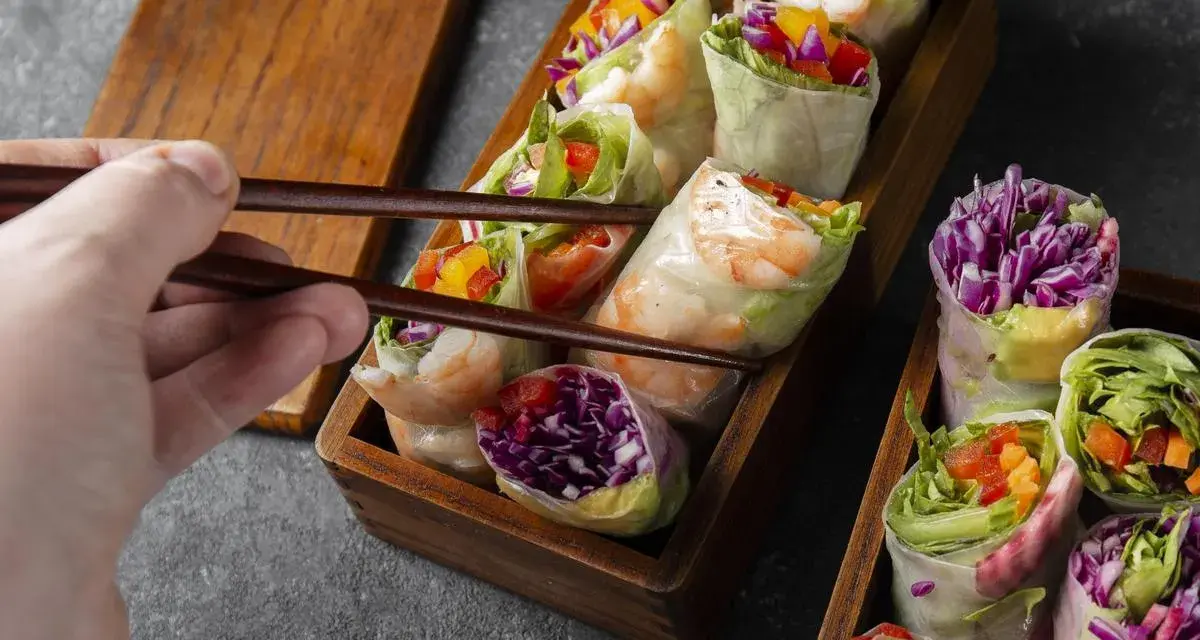 Chwytam pałeczkami świeże sajgonki z krewetkami, czerwoną kapustą i warzywami. Idealne co do sushi!