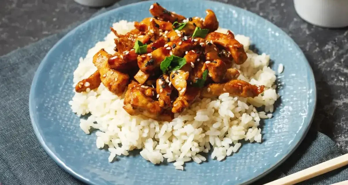 Pyszny kurczak po japońsku w sosie teriyaki, podany na ryżu z sezamem i szczypiorkiem. Idealny posiłek dla miłośników azjatyckich smaków.