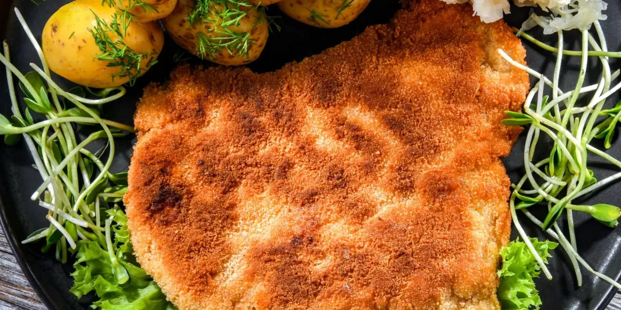 Chrupiący schabowy w panko, podany z młodymi ziemniaczkami, surówką i kiełkami. Pyszny obiad gotowy!