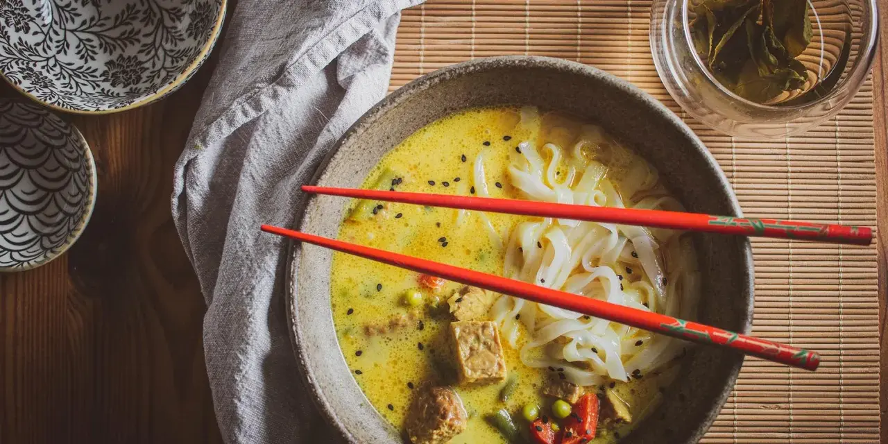 Aksamitna zupa laksa z makaronem ryżowym, tofu i warzywami. Idealny przepis na rozgrzewający posiłek.
