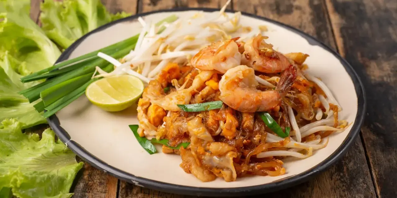 Pad Thai z krewetkami, kiełkami i limonką. Pyszne tajskie przepisy na talerzu.