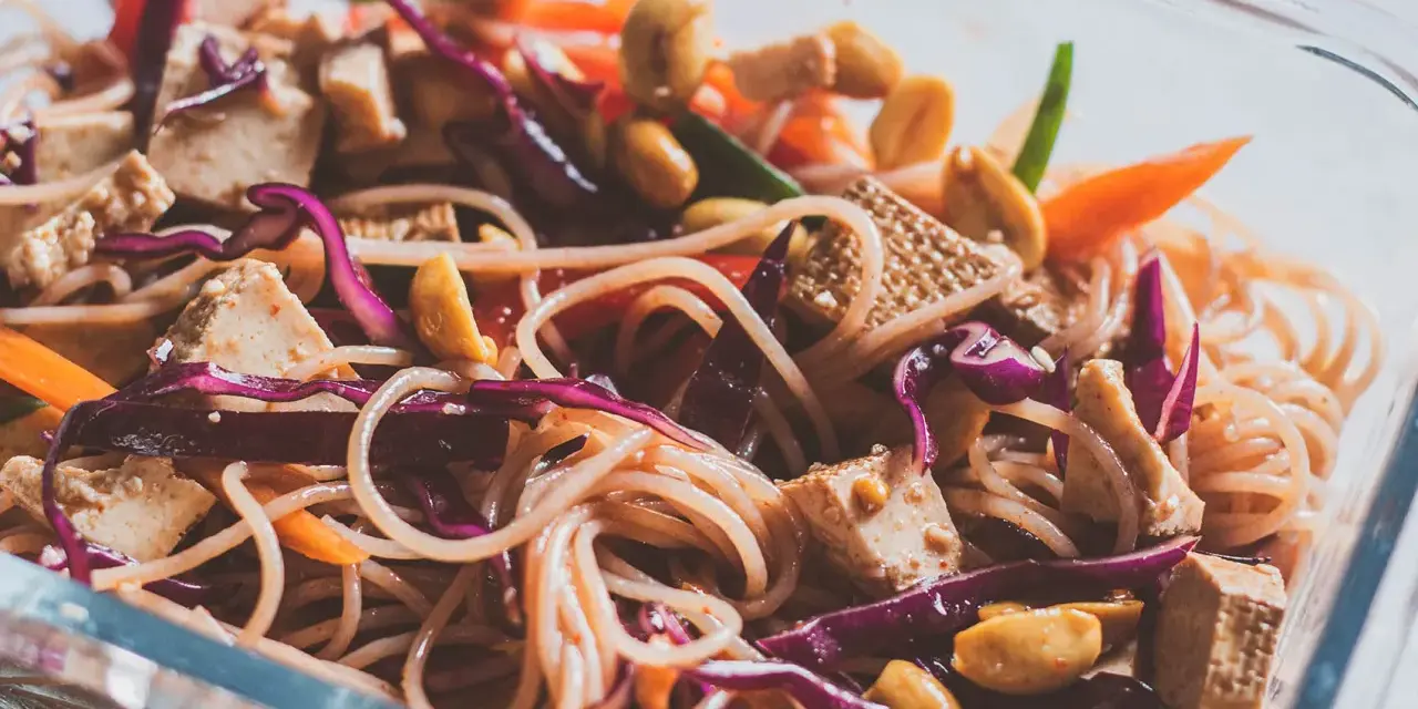 Kolorowa sałatka z makaronem vermicelli, tofu, orzeszkami ziemnymi i warzywami.