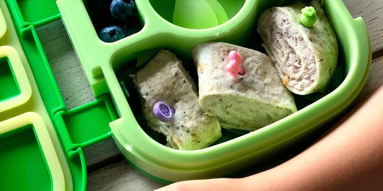 Kolorowy bento box z tortillami, jagodami i warzywami. Idealny lunchbox dla dziecka, który zachęca do jedzenia.
